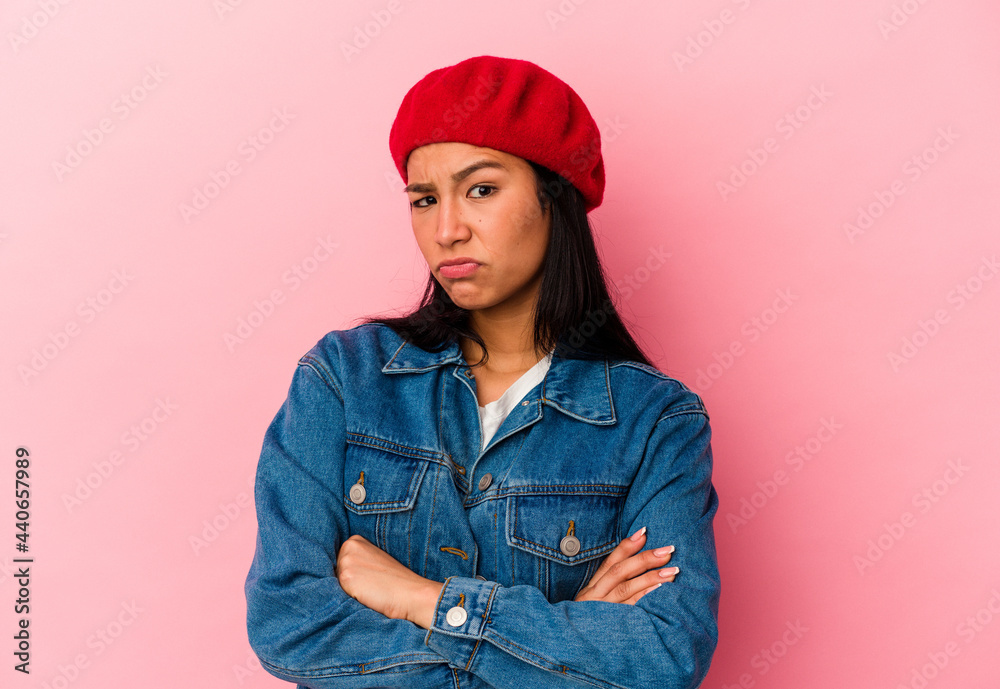 Young Venezuelan woman isolated on pink background frowning face in displeasure, keeps arms folded. Young Venezuelan woman isolated on pink background frowning face in displeasure, keeps arms folded.