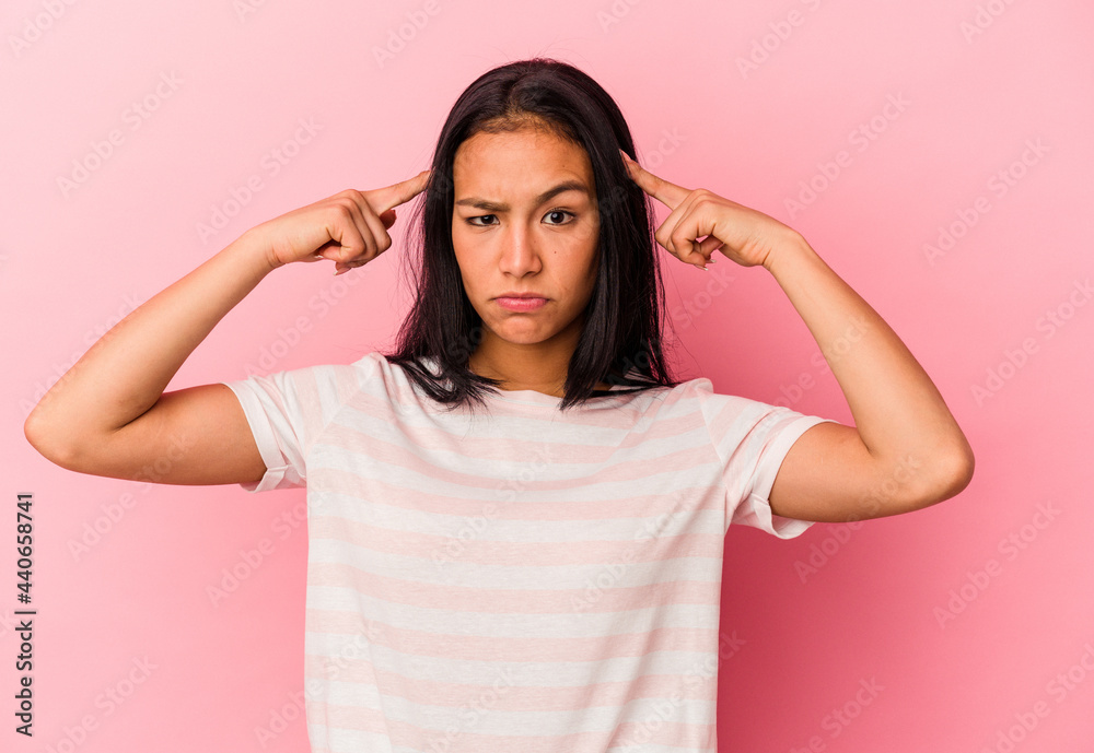 Young Venezuelan woman isolated on pink background focused on a task, keeping forefingers pointing head. Young Venezuelan woman isolated on pink background focused on a task, keeping forefingers pointing head.