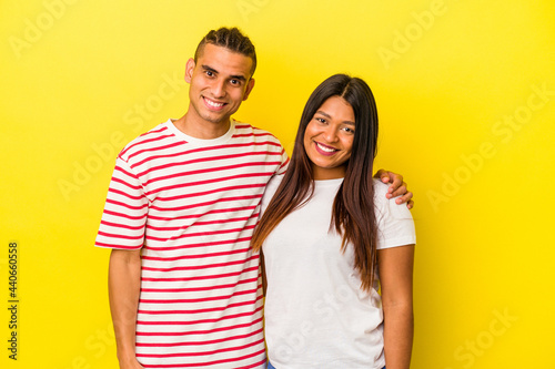 Young latin couple isolated on yellow background happy, smiling and cheerful.
