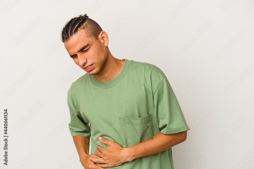 Young venezuelan man isolated on white background having a liver pain, stomach ache. Young venezuelan man isolated on white background having a liver pain, stomach ache.