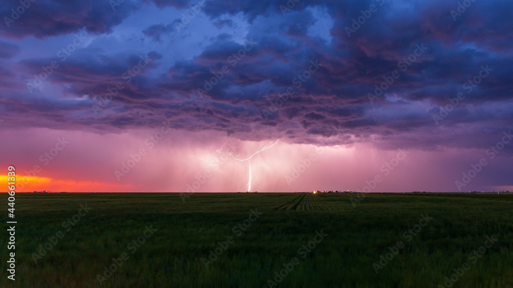 Lightning bolt strikes at dusk on the Wyoming / Colorado border with dark storm clouds overhead