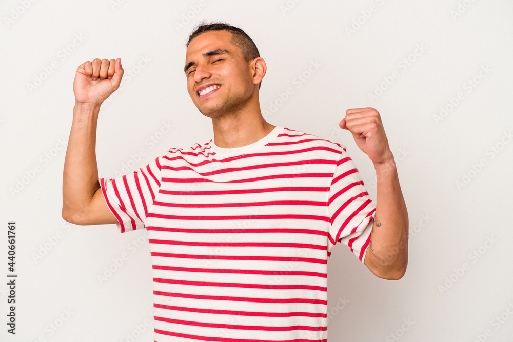 Young venezuelan man isolated on white background celebrating a special day, jumps and raise arms with energy.