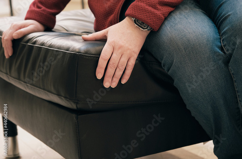 Obraz na plátně Caucasian woman in the store chooses for buy an ottoman made of brown leather