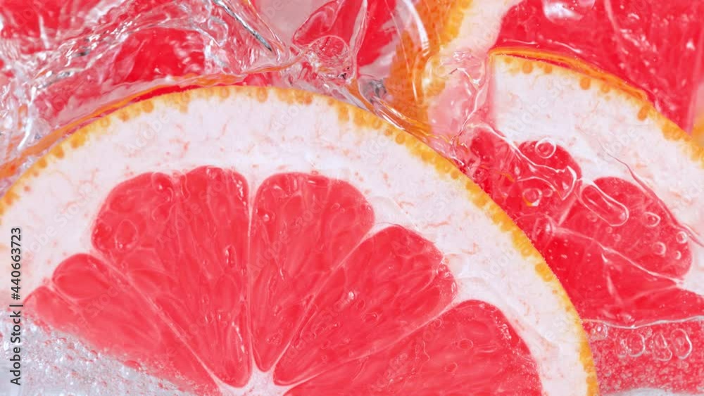 Super Slow Motion Shot of Pouring Water on Grapefruit Slices and Ice Cubes in Glass at 1000 fps. Super Slow Motion Shot of Pouring Water on Grapefruit Slices and Ice Cubes in Glass at 1000 fps.