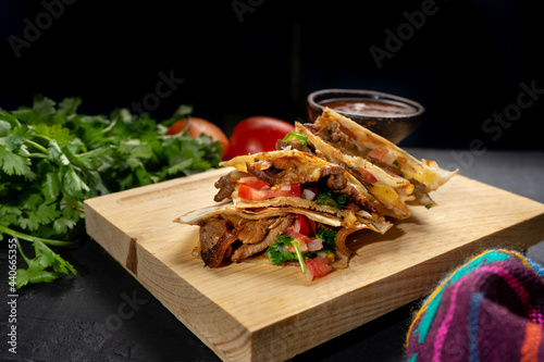 Grill steak mulitas with fresh sauce and cheese on dark background. Mexican food photo