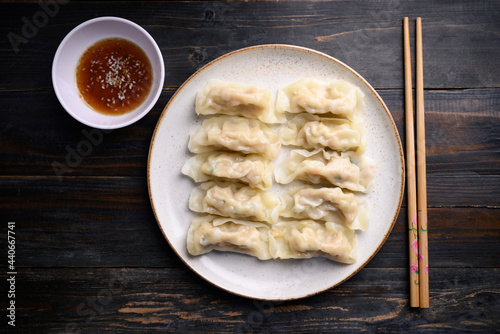 Steamed wonton dumpling stuffed with minced pork on plate eating with sesame oil sauce, Asian cuisine photo