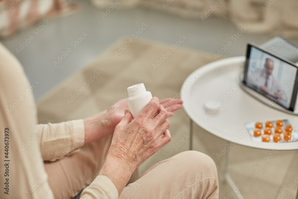 An elderly woman communicates remotely via a tablet with her doctor and takes medications according to his recommendations. Telemedicine concept An elderly woman communicates remotely via a tablet with her doctor and takes medications according to his recommendations. Telemedicine concept