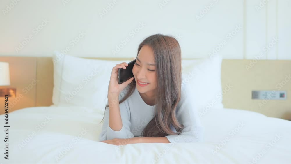Attractive Thai Woman talking on smartphone, Smiling Asian Girl Lying on the Big Bed in Casual Clothes and Having a Funny Flirting Conversation
Attractive Thai Woman talking on smartphone, Smiling Asian Girl Lying on the Big Bed in Casual Clothes and Having a Funny Flirting Conversation
