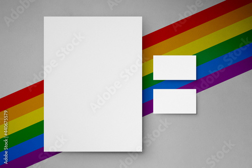 Colorful rainbow gay pride background with paper letter, bag, business card,stationery  and phone mail premium mockup simulation with a flag symbol of Lgbtq social movement behind stationary
