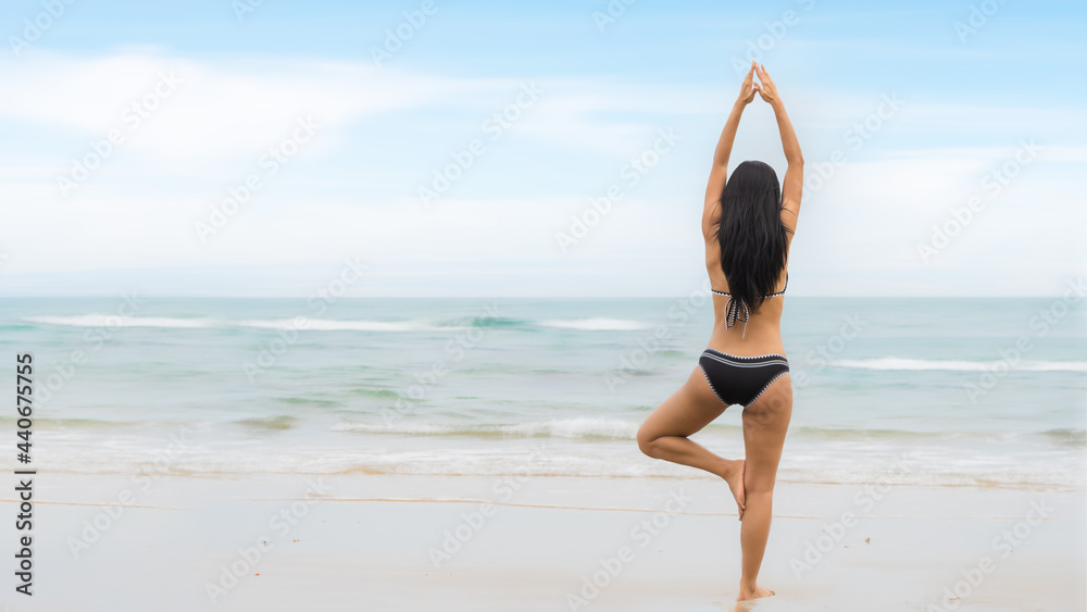 woman in bikini have standing meditation and yoga on beach in summer