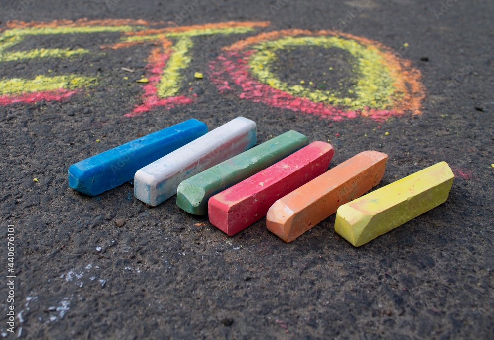 a few colored crayons on the gray asphalt a few colored crayons on the gray asphalt