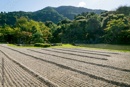 Stone zen garden with with raked gravel along pond at Sogenchi garden at Tenryu-ji temple in Kyoto, Japan photo