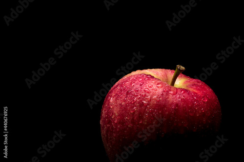 wet red delicious apple close-up on black background