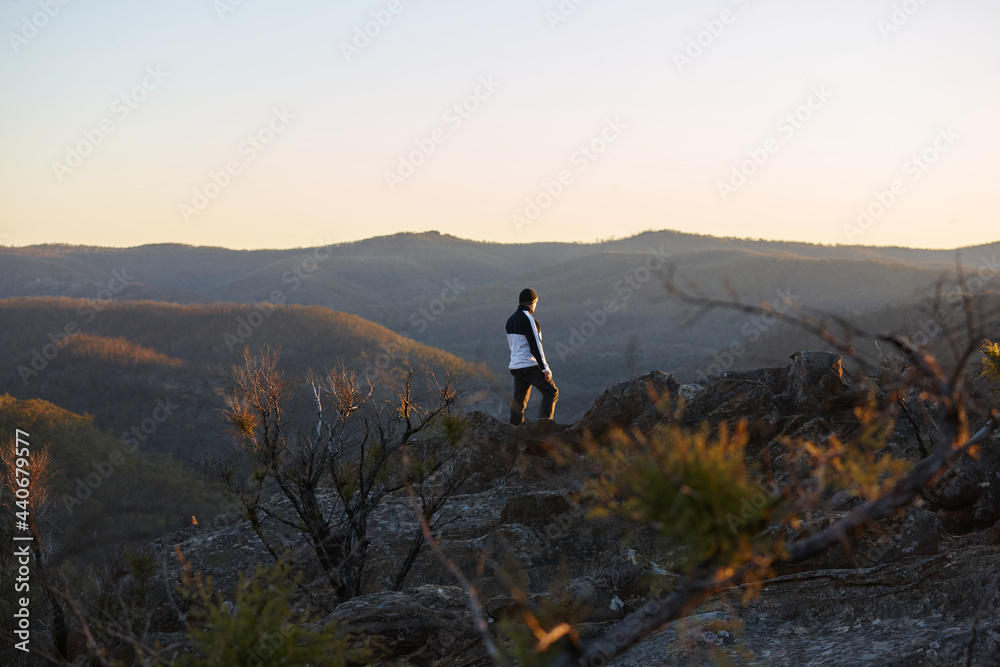 Man standing looking out over mountains on sunset Man standing looking out over mountains on sunset