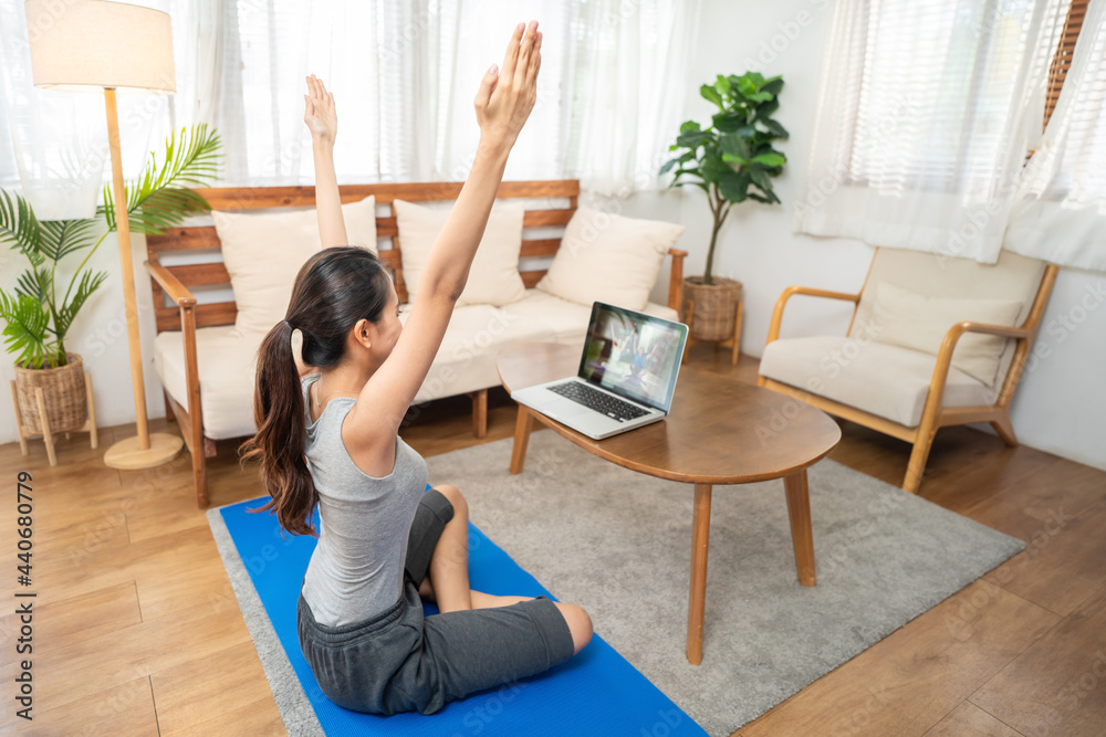 © Kawee - Asian girl learning yoga class online for exercise from video tutorial