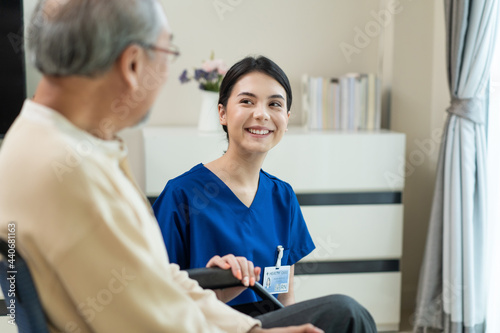 Asian female nurse invite senior male patient to talk in nursing home. 