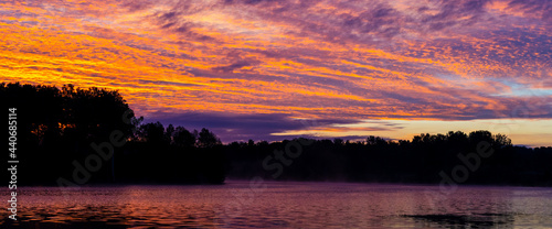 early morning or late evening dramatic sky over forest lake or river, summer panoramic landscape © MasterSergeant