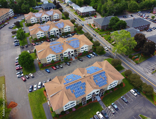 aerial view of apartment buildings with solar panel installed on roof 