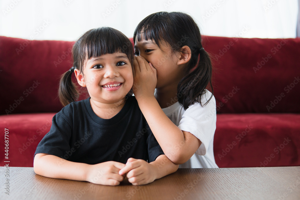 happy little Asian siblings sharing secrets happy little Asian siblings sharing secrets
