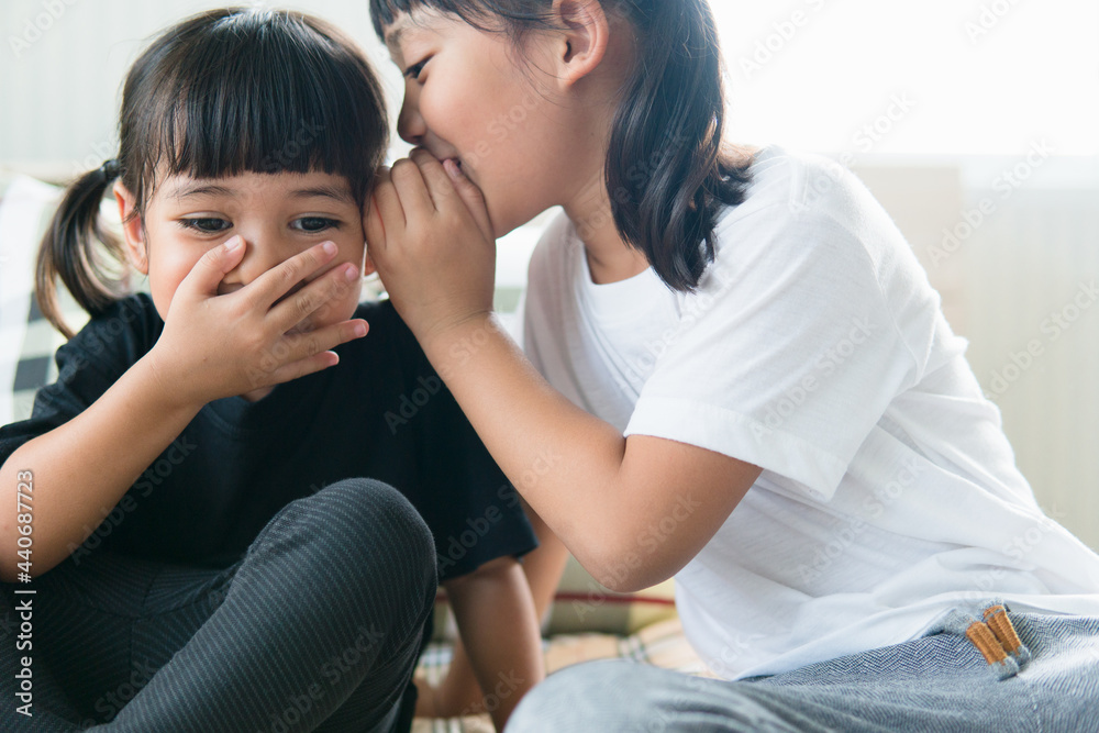 happy little Asian siblings sharing secrets happy little Asian siblings sharing secrets