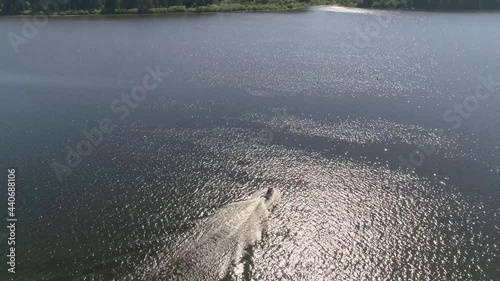 Aerial view of man ride on jetski on the city pond. The forest by the pond. Summer sunny day
 photo