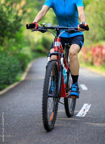 Fototapeta Naklejka Na Ścianę i Meble -  Woman cycling on tropical park trail in summer