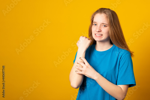 Young woman scratching her itchy arm. Skin problem.