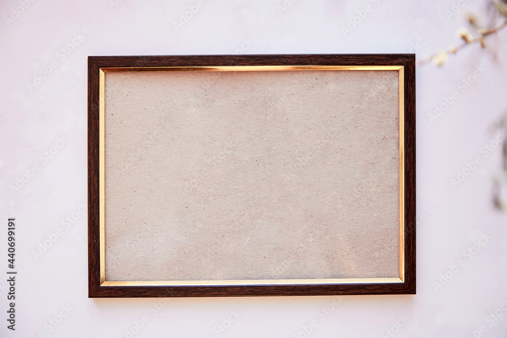 Fototapeta premium Brown frame mockup on vintage surface. Vintage frame with dry Lagurus ovatus grass and gipsophila. Beige bakground, Scandinavian interior. High quality photo