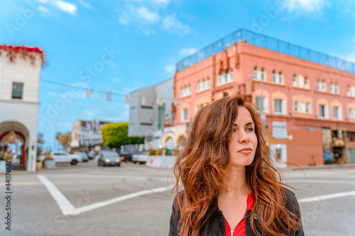 Young woman on the street with a blue sky on Venice Beach and the famous inscription, Los Angeles