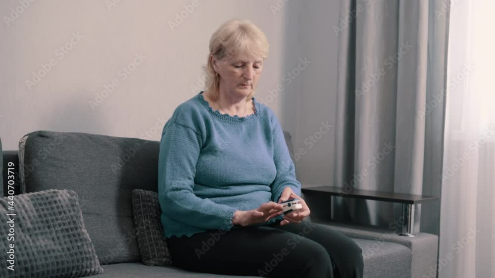 Elderly woman measures oxygen saturation. Pensioner uses pulse oximeter at home. Slider shot. Elderly woman measures oxygen saturation. Pensioner uses pulse oximeter at home. Slider shot.