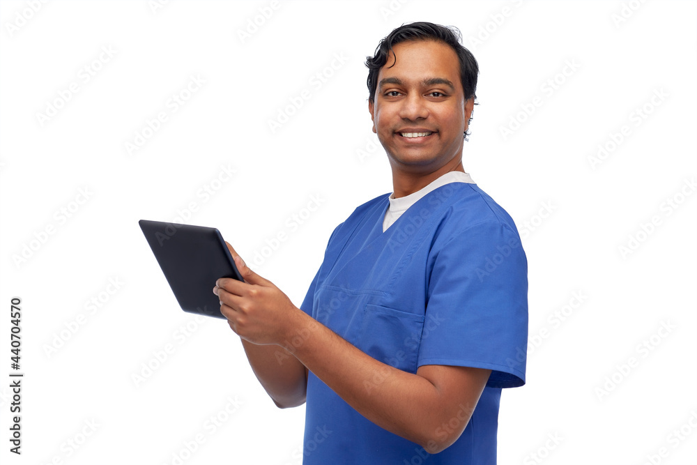 medicine, healthcare and technology concept - happy smiling indian doctor or male nurse in blue uniform using tablet pc computer over white background medicine, healthcare and technology concept - happy smiling indian doctor or male nurse in blue uniform using tablet pc computer over white background