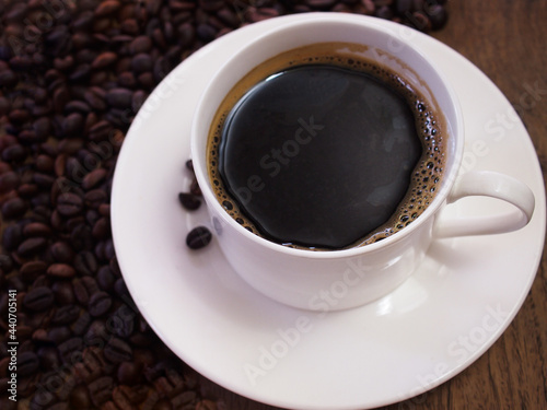 Top view aroma black coffee with coffee beans on wooden background. 