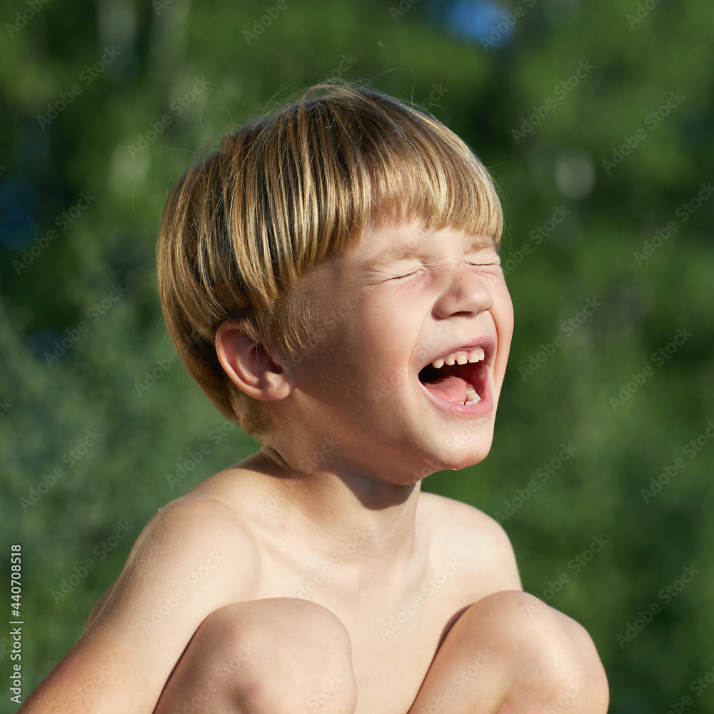 portrait of little angry boy shouting and screaming with closed eyea on green natural background, outdoor portrait of little angry boy shouting and screaming with closed eyea on green natural background, outdoor