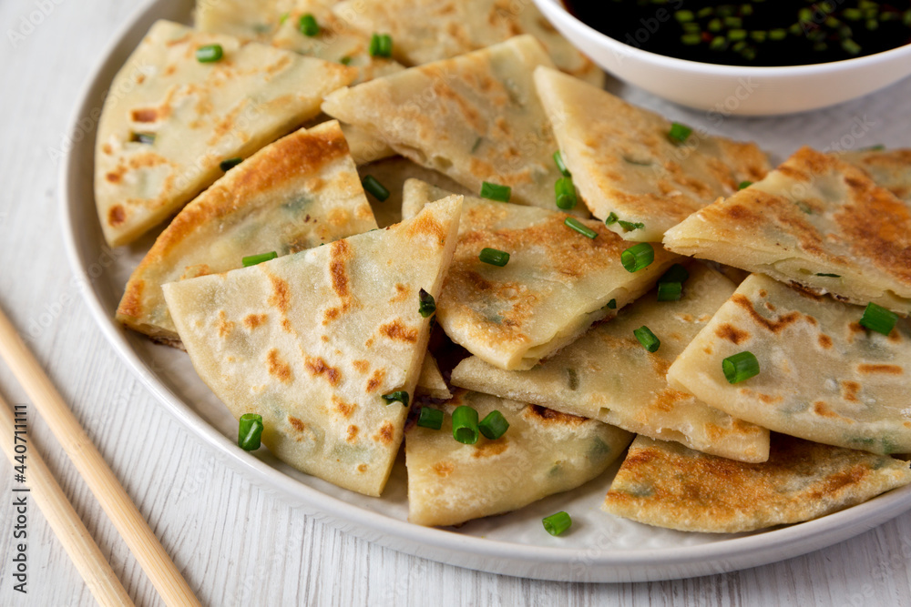 Homemade Scallion Pancakes with Soy Dipping Sauce on a white wooden background, side view. Close-up. Homemade Scallion Pancakes with Soy Dipping Sauce on a white wooden background, side view. Close-up.
