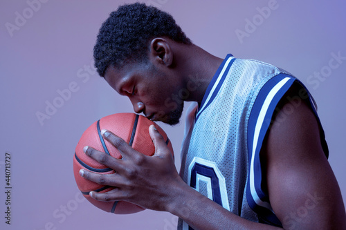 Serious basketball player with ball in studio