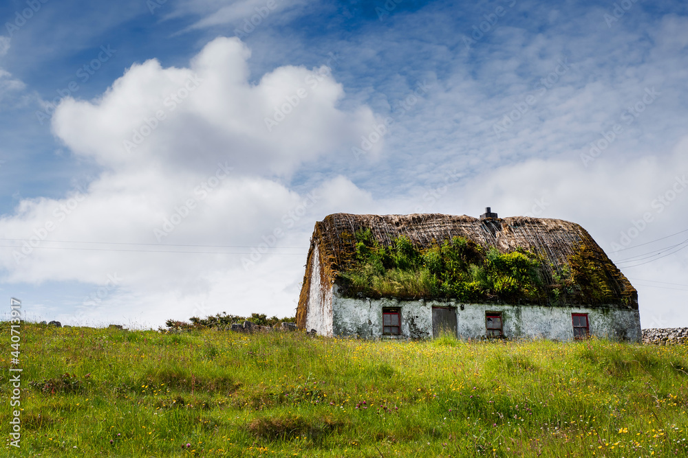 Old country house in a field on a warm sunny day, blue sky. Inishmore, Aran Islands, County Galway, Ireland. Irish landscape Old country house in a field on a warm sunny day, blue sky. Inishmore, Aran Islands, County Galway, Ireland. Irish landscape