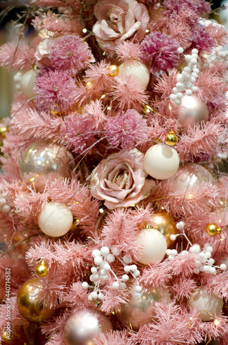 Christmas background. Pink Christmas tree branches with balls and flowers in monochrome and pastel colors, selective focus