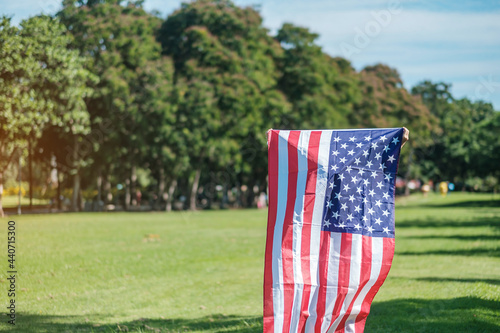 Woman traveling with United States of America flag in park outdoor. USA holiday of Veterans, Memorial, Independence ( Fourth of July) and Labor Day concept