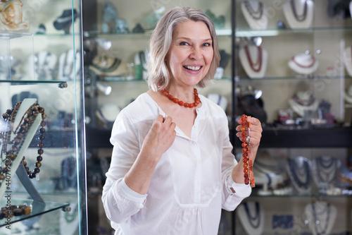Obraz na plátně Woman chooses cornelian agate jewelry in boutique