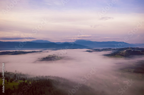 Dawn fog covers the lowlands between the mountains