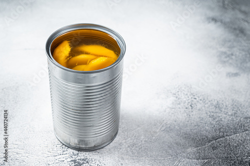 Canned mango slices in syrup in a metal can. White background. Top view. Copy space