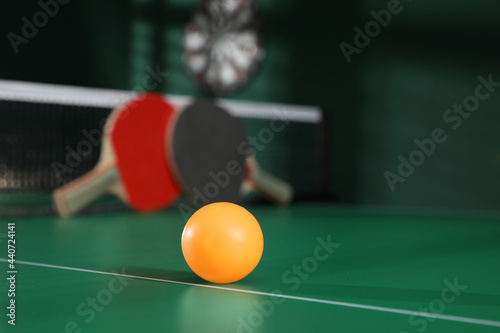 Photography Orange ball on green ping pong table indoors. Space for text