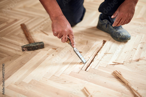 Repairman restoring old parquet hardwood floor.