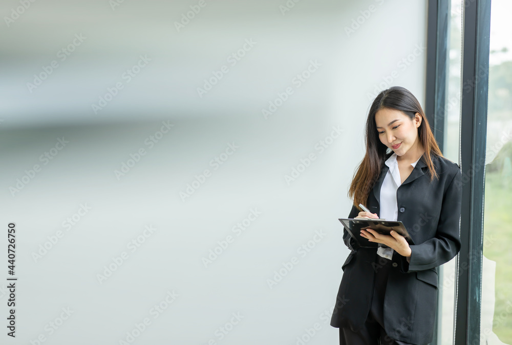 Image of happy asian young business woman posing isolated over grey wall background at office. Image of happy asian young business woman posing isolated over grey wall background at office.