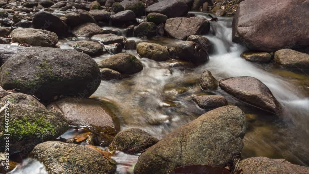 water steam in rocky river. texture of rocks and smooth clean water in sunlight. tropical forest and waterfall. environment in rainforest. nature and ecology landscape background. wet weather motion water steam in rocky river. texture of rocks and smooth clean water in sunlight. tropical forest and waterfall. environment in rainforest. nature and ecology landscape background. wet weather motion