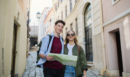 Young couple travelers with map in city on holiday, sightseeing. photo