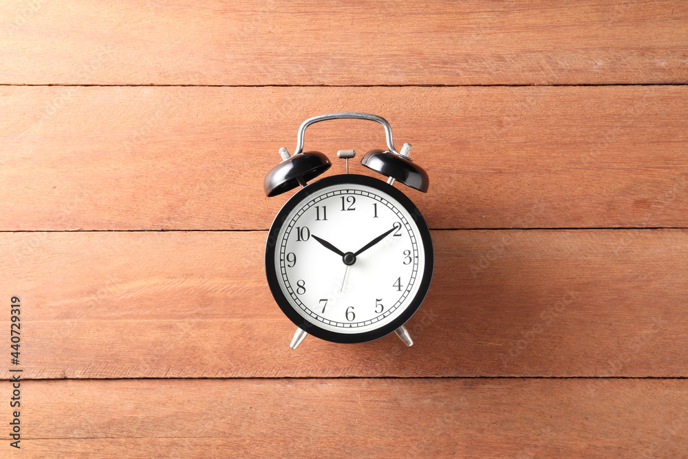 black alarm clock on wood background with copy space for text or image black alarm clock on wood background with copy space for text or image