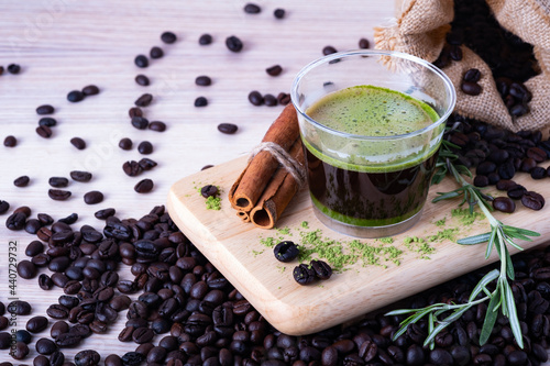 Hot espresso black coffee matcha green tea mix shot with green tea poeder and coffee beans on cut board with copy space for text. coffee menu concept.