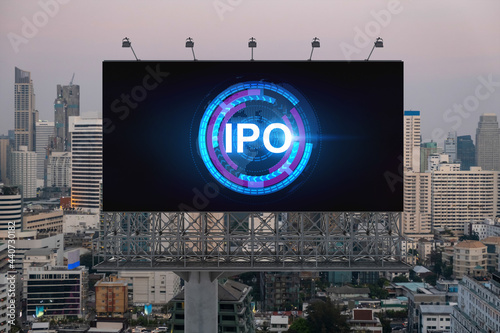 IPO icon hologram on road billboard over sunset panorama city view of Bangkok. The hub of initial public offering in Southeast Asia. The concept of exceeding business opportunities.
