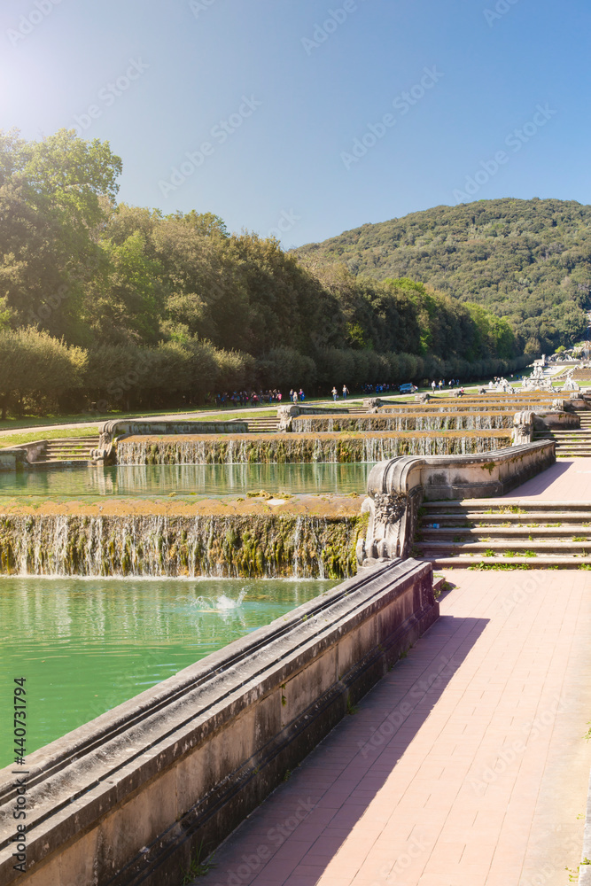 Royal Palace in Caserta, Italy - April 10, 2017: Baroque style cascade fountain along the stairs in the garden of the Royal Palace Royal Palace in Caserta, Italy - April 10, 2017: Baroque style cascade fountain along the stairs in the garden of the Royal Palace